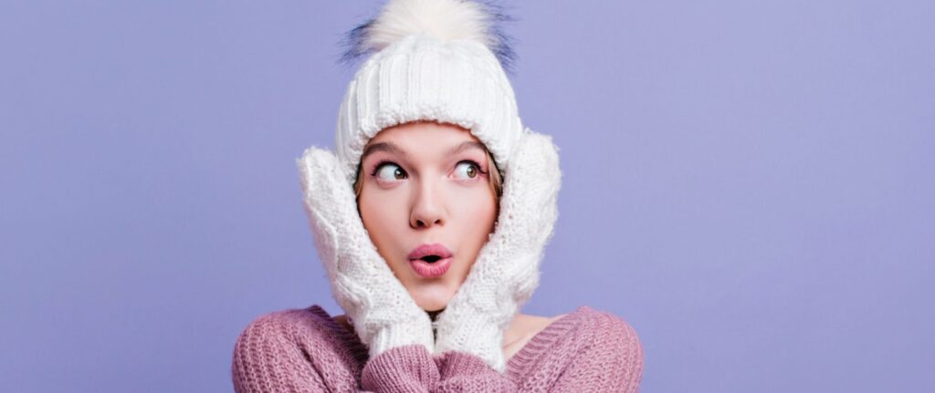zszokowana-kobieta-w-zimowej-czapce-pielęgnacja-twarzy-zimą
