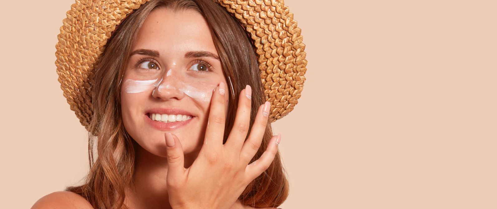 letnia-pielęgnacja-twarzy-uśmiechnięta-kobieta-w-kapeluszu-z-kremem-do-twarzy